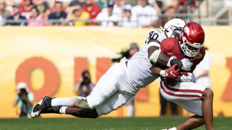 Jan 1, 2022; Tampa, FL, USA; Penn State Nittany Lions linebacker Jesse Luketa (40) tackles Arkansas Razorbacks wide receiver Bryce Stephens (14) during the first half during the 2022 Outback Bowl at Raymond James Stadium. Mandatory Credit: Matt Pendleton-USA TODAY Sports