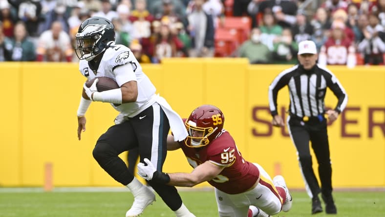 Jan 2, 2022; Landover, Maryland, USA; Philadelphia Eagles quarterback Jalen Hurts (1) scrambles as Washington Football Team defensive end Casey Toohill (95) defends during the first half at FedExField. Mandatory Credit: Brad Mills-USA TODAY Sports