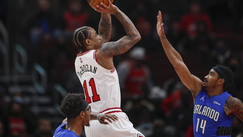 Jan 3, 2022; Chicago, Illinois, USA; Chicago Bulls forward DeMar DeRozan (11) shoots against Orlando Magic guard Gary Harris (14) during the first half at United Center. Mandatory Credit: Kamil Krzaczynski-USA TODAY Sports