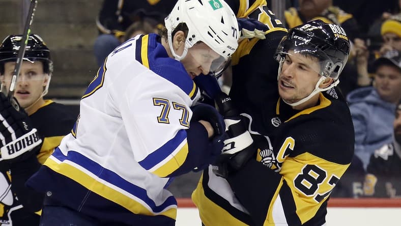 Jan 5, 2022; Pittsburgh, Pennsylvania, USA; St. Louis Blues defenseman Niko Mikkola (77) and Pittsburgh Penguins center Sidney Crosby (87) exchange punches during the second period at PPG Paints Arena. Mandatory Credit: Charles LeClaire-USA TODAY Sports