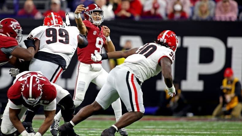 Jan 10, 2022; Indianapolis, IN, USA; Alabama Crimson Tide quarterback Bryce Young (9) throws a pass against Georgia Bulldogs defensive lineman Jordan Davis (99) during the second quarter in the 2022 CFP college football national championship game at Lucas Oil Stadium. Mandatory Credit: Trevor Ruszkowski-USA TODAY Sports