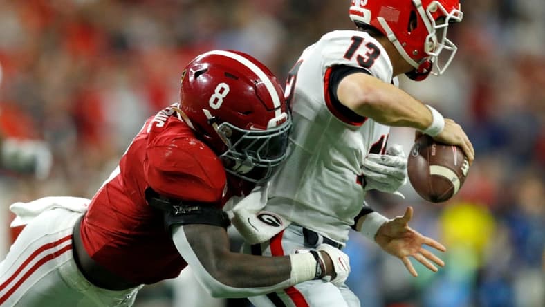 Alabama Crimson Tide linebacker Christian Harris (8) causes Georgia Bulldogs quarterback Stetson Bennett (13) to fumble and turn over the ball Monday, Jan. 10, 2022, during the College Football Playoff National Championship at Lucas Oil Stadium in Indianapolis.