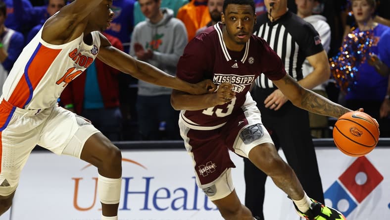 Jan 19, 2022; Gainesville, Florida, USA; Mississippi State Bulldogs forward D.J. Jeffries (13) drives to the basket as Florida Gators guard Kowacie Reeves (14) defends during the first half at Billy Donovan Court at Exactech Arena. Mandatory Credit: Kim Klement-USA TODAY Sports