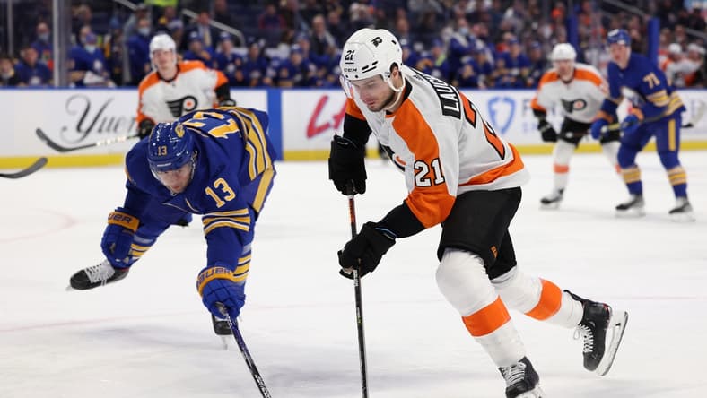 Jan 22, 2022; Buffalo, New York, USA; Buffalo Sabres defenseman Mark Pysyk (13) tries to block a shot by Philadelphia Flyers center Scott Laughton (21) during the first period at KeyBank Center. Mandatory Credit: Timothy T. Ludwig-USA TODAY Sports