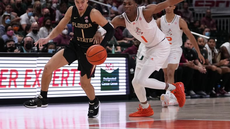 Jan 22, 2022; Coral Gables, Florida, USA; Florida State Seminoles guard Jalen Warley (1) and Miami Hurricanes forward Anthony Walker (1) chase a loose ball during the first half at Watsco Center. Mandatory Credit: Jasen Vinlove-USA TODAY Sports