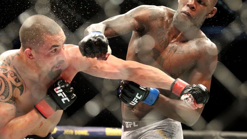 Oct 5, 2019; Melbourne, AUSTRALIA; Israel Adesanya (blue gloves) and Robert Whittaker (red gloves) during UFC 243 at Marvel Stadium. Mandatory Credit: Jasmin Frank-USA TODAY Sports