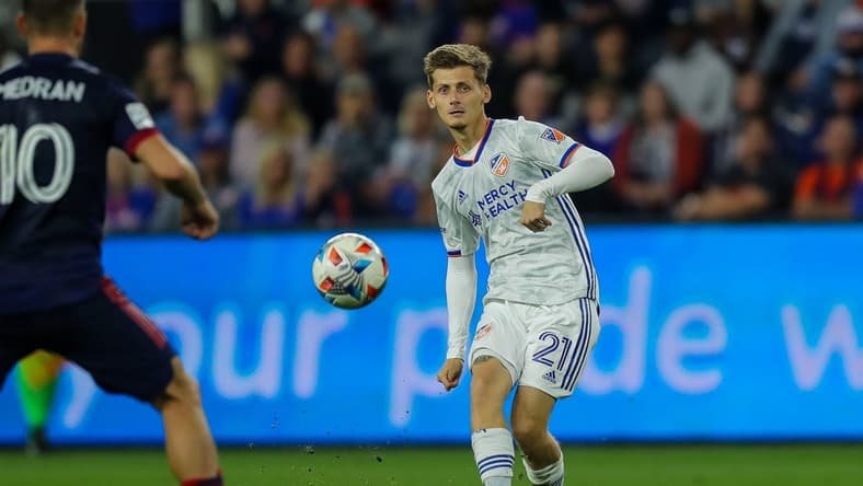 Oct 20, 2021; Cincinnati, OH, USA; FC Cincinnati midfielder Kyle Scott (21) kicks the ball against Chicago Fire FC midfielder Alvaro Medran (10) in the second half at TQL Stadium. Mandatory Credit: Katie Stratman-USA TODAY Sports