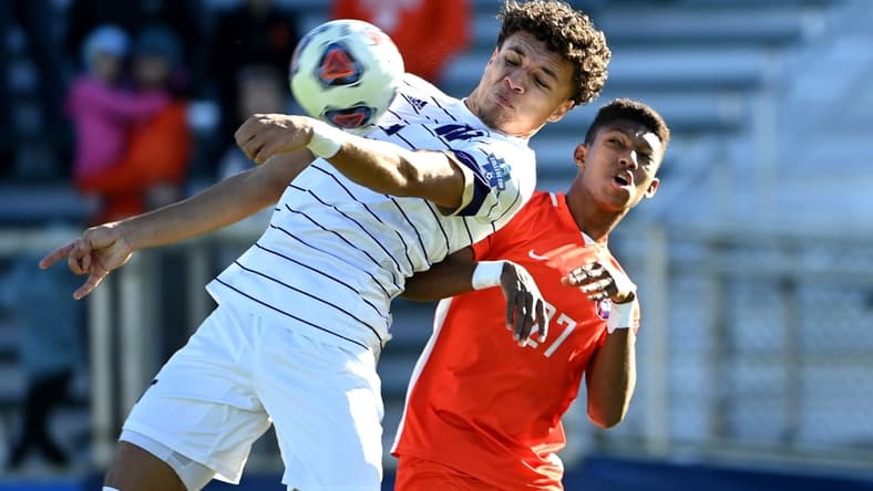 Dec 12, 2021; Cary, NC, USA;  Washington defender Kendall Burks (2) and Clemson forward Isaiah Reid (27) fight for the ball in the first half at WakeMed Soccer Park. Mandatory Credit: Bob Donnan-USA TODAY Sports