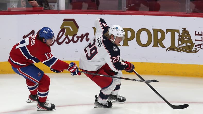 Feb 12, 2022; Montreal, Quebec, CAN; Columbus Blue Jackets left wing Patrik Laine (29) plays the puck against Montreal Canadiens right wing Josh Anderson (17) during the first period at Bell Centre. Mandatory Credit: Jean-Yves Ahern-USA TODAY Sports