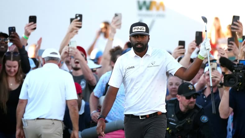 Feb 12, 2022; Scottsdale Arizona, USA; Sahith Theegala raises his club after chipping from the rough in the crowd on the 18th hole during Round 3 at the WM Phoenix Open. Mandatory Credit: Patrick Breen-USA TODAY Sports