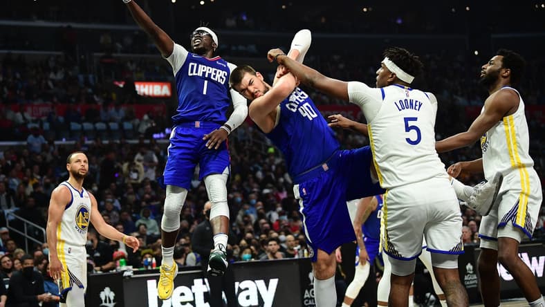 Feb 14, 2022; Los Angeles, California, USA; Los Angeles Clippers guard Reggie Jackson (1) moves to the basket as center Ivica Zubac (40) provides coverage against Golden State Warriors center Kevon Looney (5) during the first half at Crypto.com Arena. Mandatory Credit: Gary A. Vasquez-USA TODAY Sports