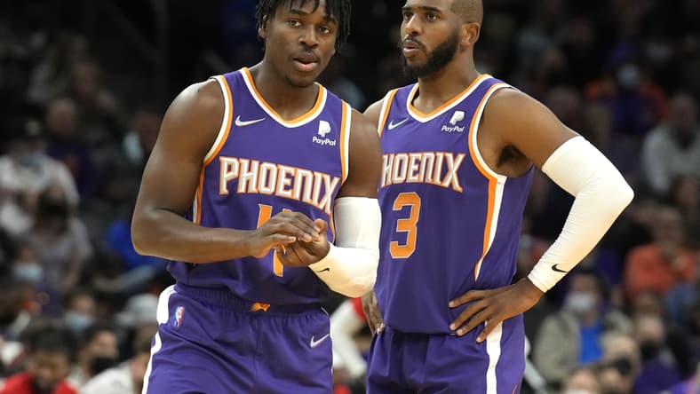 Feb 16, 2022; Phoenix, Arizona, USA; Phoenix Suns guard Aaron Holiday (4) and guard Chris Paul (3) talk during a time-out against the Houston Rockets at Footprint Center. Mandatory Credit: Rick Scuteri-USA TODAY Sports