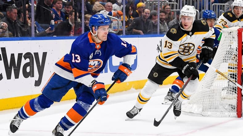 Feb 17, 2022; Elmont, New York, USA;  New York Islanders center Mathew Barzal (13) brings the puck put from behind the net chased by Boston Bruins center Charlie Coyle (13) during the second period at UBS Arena. Mandatory Credit: Dennis Schneidler-USA TODAY Sports