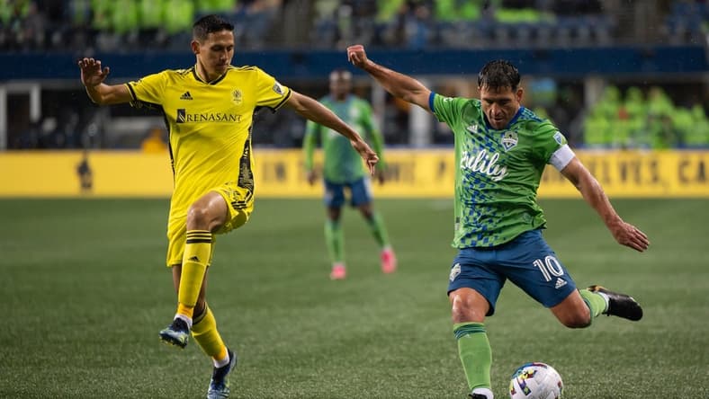 Feb 27, 2022; Seattle, Washington, USA; Seattle Sounders midfielder Nicol s Lodeiro (10) crosses the ball while being defended by Nashville SC midfielder Sean Davis (54) during the second half at Lumen Field. Nashville defeated Seattle 1-0. Mandatory Credit: Steven Bisig-USA TODAY Sports