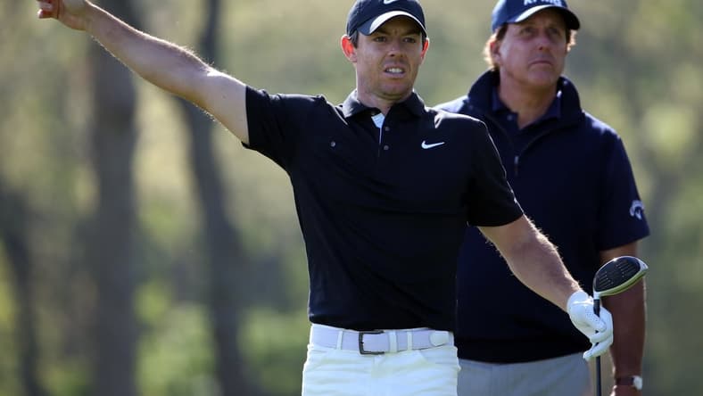 May 17, 2019; Bethpage, NY, USA; Rory McIlroy reacts after his shot from the 12th tee as Phil Mickelson (right) looks on during the second round of the PGA Championship golf tournament at Bethpage State Park - Black Course. Mandatory Credit: Peter Casey-USA TODAY Sports