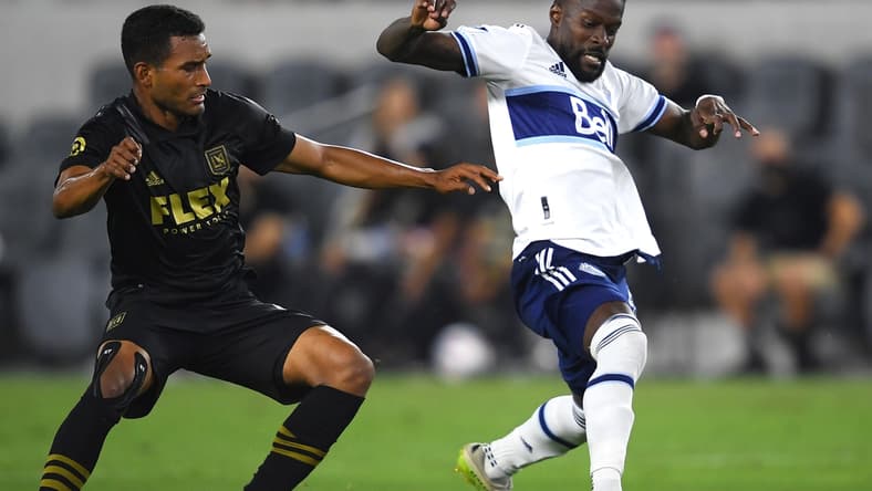 Jul 24, 2021; Los Angeles, CA, USA; Los Angeles FC defender Eddie Segura (4) and Vancouver Whitecaps forward Tosaint Ricketts (87) battle for the ball in the second half at Banc of California Stadium. Mandatory Credit: Jayne Kamin-Oncea-USA TODAY Sports