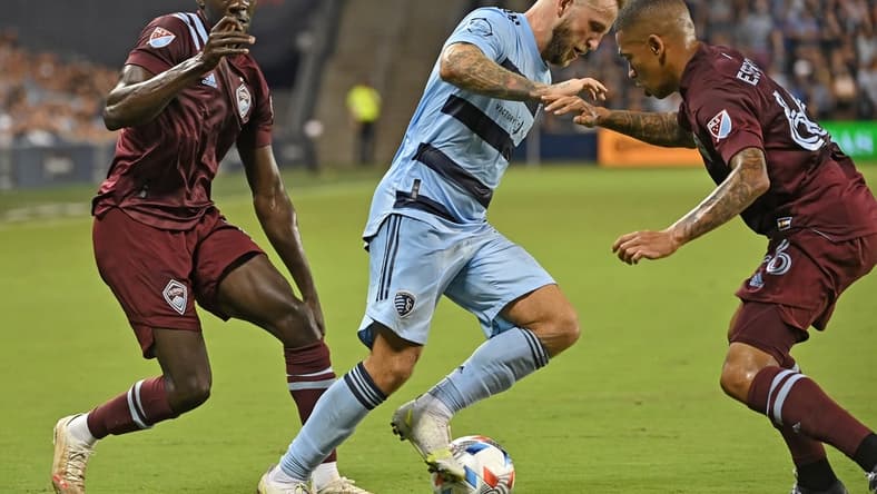 Aug 28, 2021; Kansas City, Kansas, USA;  Sporting Kansas City forward Johnny Russell (7) dribbles the ball up field against Colorado Rapids defender Lucas Esteves (66) during the second half at Children's Mercy Park. Mandatory Credit: Peter Aiken-USA TODAY Sports