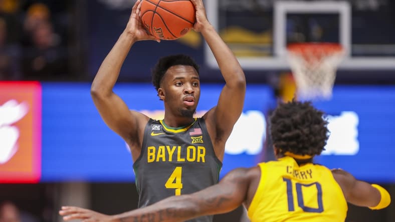 Jan 18, 2022; Morgantown, West Virginia, USA; Baylor Bears guard LJ Cryer (4) looks to pass while defended by West Virginia Mountaineers guard Malik Curry (10) during the first half at WVU Coliseum. Mandatory Credit: Ben Queen-USA TODAY Sports