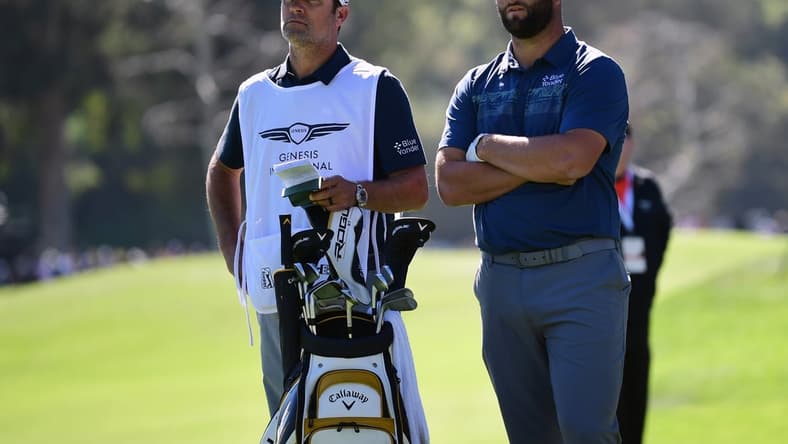 Feb 18, 2022; Pacific Palisades, California, USA; Jon Rahm speaks with caddy Adam Hayes before playing his shot on the eighth fairway during the second round of the Genesis Invitational golf tournament. Mandatory Credit: Gary A. Vasquez-USA TODAY Sports