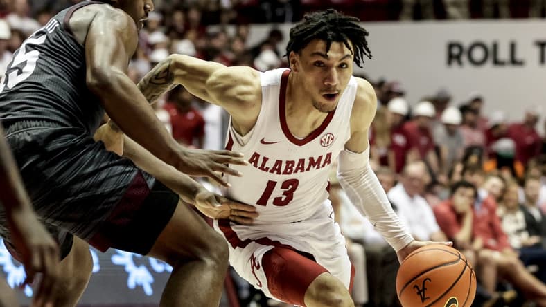 Mar 2, 2022; Tuscaloosa, Alabama, USA; Alabama Crimson Tide guard Jahvon Quinerly (13) dribbles around Texas A&M Aggies forward Henry Coleman III (15) during the second half at Coleman Coliseum. Mandatory Credit: Butch Dill-USA TODAY Sports