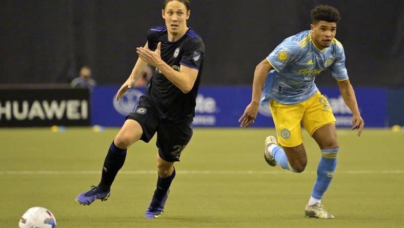 Mar 5, 2022; Montreal, Quebec, CAN; CF Montreal midfielder Lassi Lappalainen (21) and Philadelphia Union defender Nathan Harriel (26) chase the ball during the first half at Olympic Stadium. Mandatory Credit: Eric Bolte-USA TODAY Sports