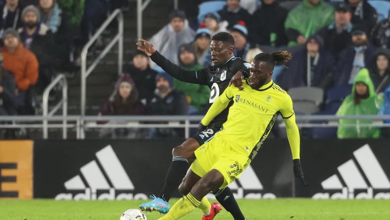 Mar 5, 2022; Saint Paul, Minnesota, USA; Minnesota United defender Bakaye Dibassy (12) and Nashville SC forward C.J. Sapong (17) fight for the ball in the first half at Allianz Field. Mandatory Credit: Matt Krohn-USA TODAY Sports
