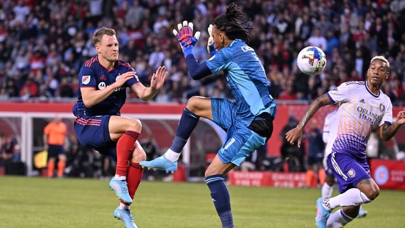 Mar 5, 2022; Chicago, Illinois, USA; Chicago Fire FC midfielder Fabian Herbers (21) prepares to collide with Orlando City SC goalkeeper Pedro Gallese (1) in the first half at Soldier Field. Mandatory Credit: Jamie Sabau-USA TODAY Sports