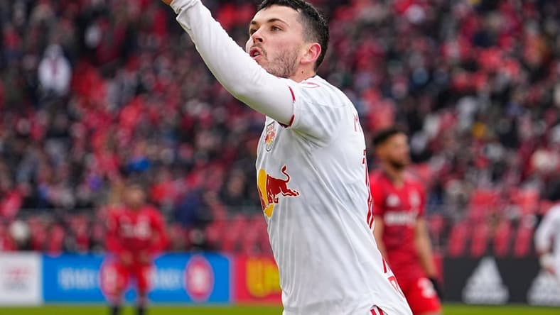 Mar 5, 2022; Toronto, Ontario, CAN; New York Red Bulls midfielder Lewis Morgan (10) signals three goals to the Toronto FC fans after scoring a hat trick in the first half at BMO Field. Mandatory Credit: John E. Sokolowski-USA TODAY Sports