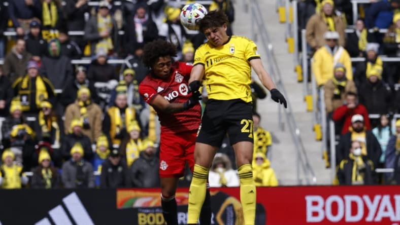 Mar 12, 2022; Columbus, Ohio, USA; Columbus Crew forward Miguel Berry (27) heads the ball against Toronto FC midfielder Jahkeele Marshall-Rutty (7) during the first half at Lower.com Field. Mandatory Credit: Greg Bartram-USA TODAY Sports