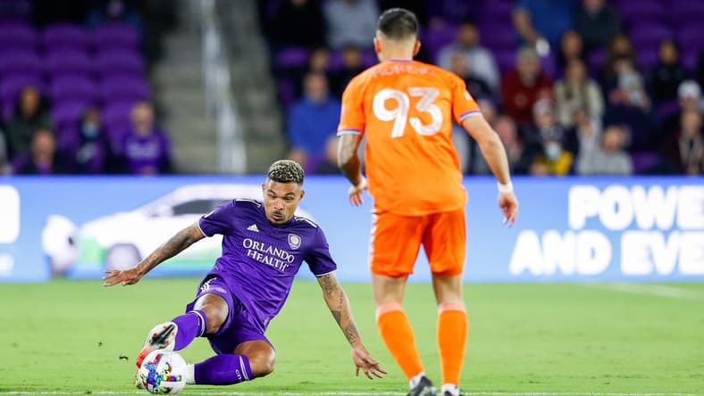 Mar 12, 2022; Orlando, Florida, USA;  Orlando City midfielder J  nior Urso (11) keeps the bay away from FC Cincinnati midfielder J  nior Moreno (93) in the first half at Orlando City Stadium. Mandatory Credit: Nathan Ray Seebeck-USA TODAY Sports