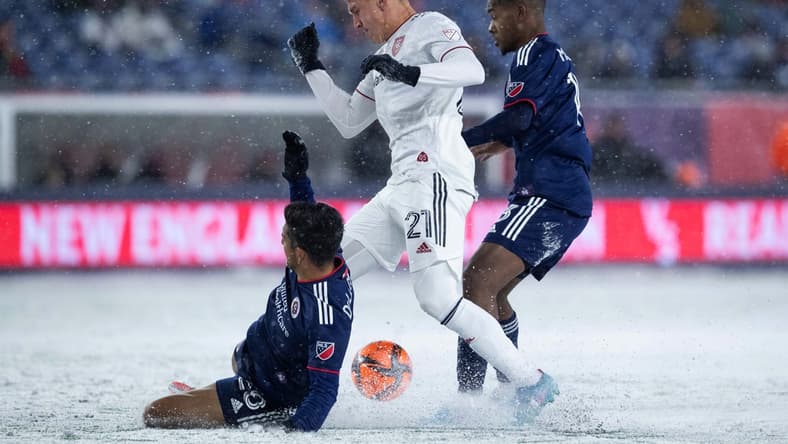 Mar 12, 2022; Foxborough, Massachusetts, USA; New England Revolution defender AJ DeLaGarza (28) slide tackles Real Salt Lake forward Tate Schmitt (21) at Gillette Stadium. Mandatory Credit: Paul Rutherford-USA TODAY Sports