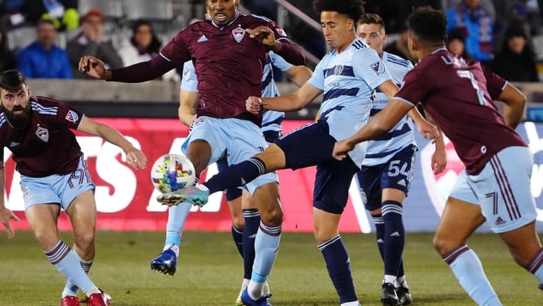 Mar 12, 2022; Commerce City, Colorado, USA; Sporting Kansas City midfielder Cameron Duke (28) and Colorado Rapids midfielder Mark-Anthony Kaye (14) reach for the ball in the first half at Dick's Sporting Goods Park. Mandatory Credit: Ron Chenoy-USA TODAY Sports