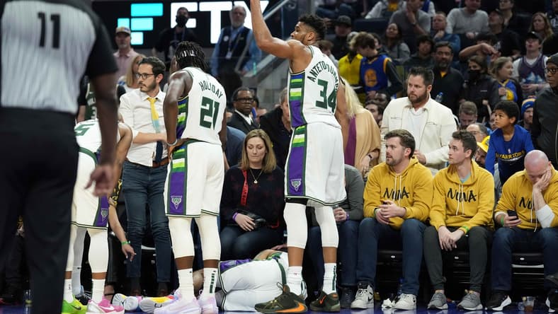 Mar 12, 2022; San Francisco, California, USA; Milwaukee Bucks forward Giannis Antetokounmpo (34) gestures as guard DeAndre' Bembry (95) lies on the floor during the third quarter at Chase Center. Mandatory Credit: Darren Yamashita-USA TODAY Sports