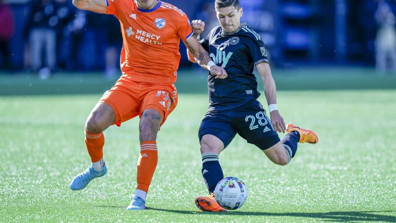Mar 26, 2022; Charlotte, North Carolina, USA; Charlotte FC defender Joseph Mora (28) kicks defended by FC Cincinnati forward Brandon Vazquez (19) during the first half at Bank of America Stadium. Mandatory Credit: Jim Dedmon-USA TODAY Sports