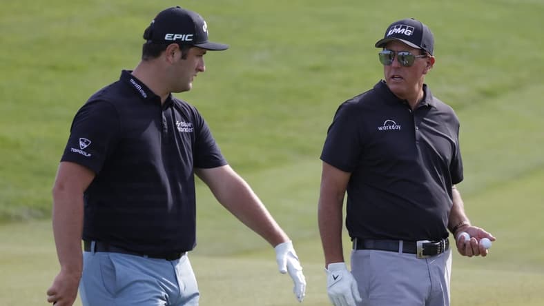 May 17, 2021; Kiawah Island, South Carolina, USA; Jon Rahm (L) and Phil Mickelson (R) talk on the sixteenth green during a practice round for the PGA Championship golf tournament at Ocean Course at Kiawah Island Resort. Mandatory Credit: Geoff Burke-USA TODAY Sports