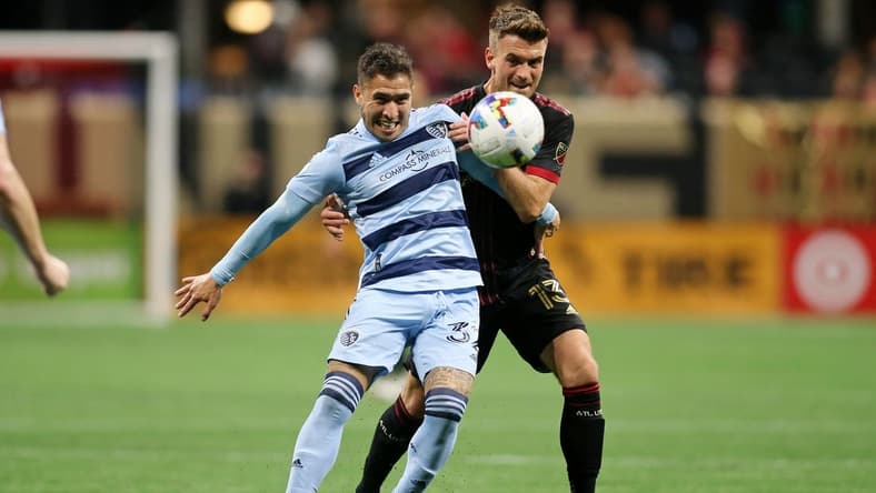 Feb 27, 2022; Atlanta, Georgia, USA; Atlanta United midfielder Amar Sejdic (13) battles for the ball against Sporting Kansas City midfielder Jose Mauri (32) during the second half at Mercedes-Benz Stadium. Atlanta United won 3-1. Mandatory Credit: Brett Davis-USA TODAY Sports