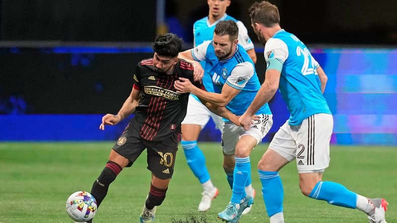 Mar 13, 2022; Atlanta, Georgia, USA; Atlanta United midfielder Marcelino Moreno (10) dribbles the ball against Charlotte FC midfielder Brandt Bronico (13) during the second half at Mercedes-Benz Stadium. Atlanta United won 2-1. Mandatory Credit: Dale Zanine-USA TODAY Sports