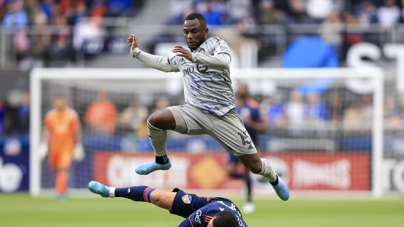 Apr 2, 2022; Cincinnati, Ohio, USA; CF Montreal defender Zachary Brault-Guillard (15) leaps over FC Cincinnati midfielder Luciano Acosta (10) in the second half at TQL Stadium. Mandatory Credit: Aaron Doster-USA TODAY Sports