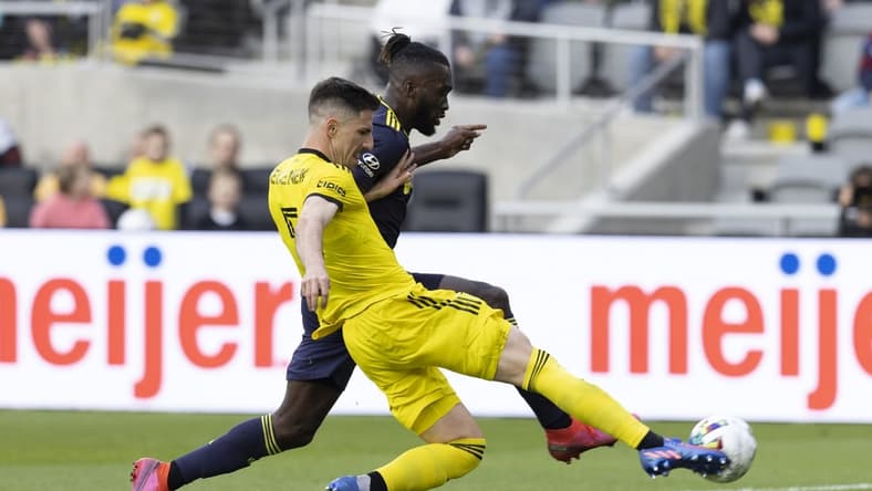 Apr 2, 2022; Columbus, Ohio, USA; Columbus Crew defender Milos Degenek (5) knocks the ball away from Nashville SC forward C.J. Sapong (17) in the first half at Lower.com Field. Mandatory Credit: Greg Bartram-USA TODAY Sports