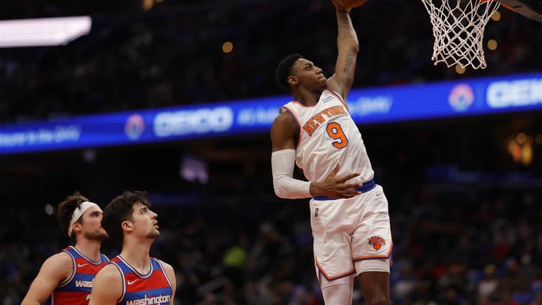 Apr 8, 2022; Washington, District of Columbia, USA; New York Knicks guard RJ Barrett (9) dunks the ball as Washington Wizards forward Deni Avdija (9) looks on in the second quarter at Capital One Arena. Mandatory Credit: Geoff Burke-USA TODAY Sports