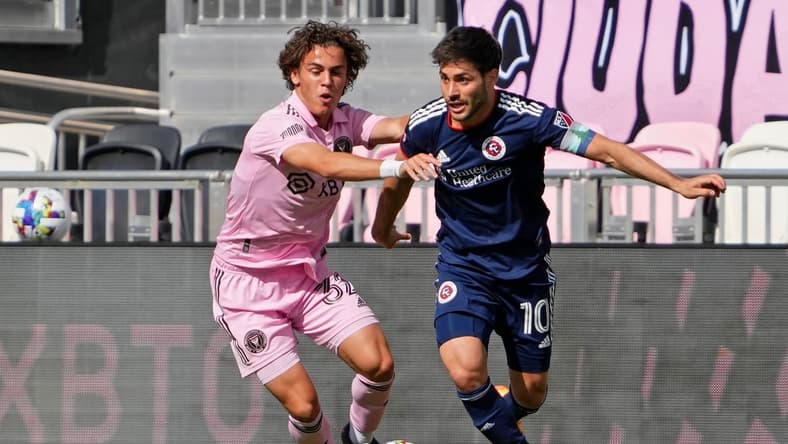 Apr 9, 2022; Fort Lauderdale, Florida, USA; New England Revolution midfielder Carles Gil (10) controls the ball while defended by Inter Miami CF defender Noah Allen (32) during the second half at DRV PNK Stadium. Mandatory Credit: Jasen Vinlove-USA TODAY Sports