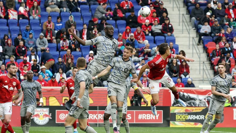 Apr 9, 2022; Harrison, New Jersey, USA; New York Red Bulls midfielder Aaron Long (33) and CF Montreal midfielder Djordje Mihailovic (8) and forward Kei Kamara (23) jump for a header in the second half at Red Bull Arena. Mandatory Credit: Vincent Carchietta-USA TODAY Sports