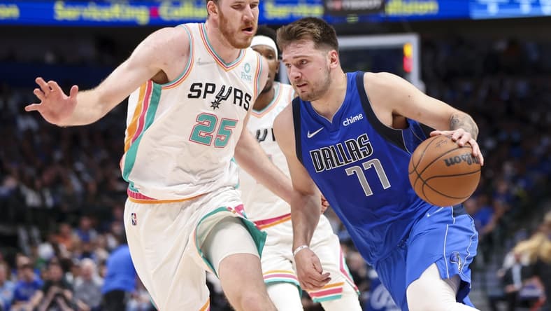Apr 10, 2022; Dallas, Texas, USA;  Dallas Mavericks guard Luka Doncic (77) drives to the basket past San Antonio Spurs center Jakob Poeltl (25) during the second quarter at American Airlines Center. Mandatory Credit: Kevin Jairaj-USA TODAY Sports
