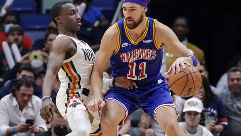 Apr 10, 2022; New Orleans, Louisiana, USA;  Golden State Warriors guard Klay Thompson (11) dribbles against New Orleans Pelicans guard Jared Harper (2) during the second half at the Smoothie King Center. Mandatory Credit: Stephen Lew-USA TODAY Sports