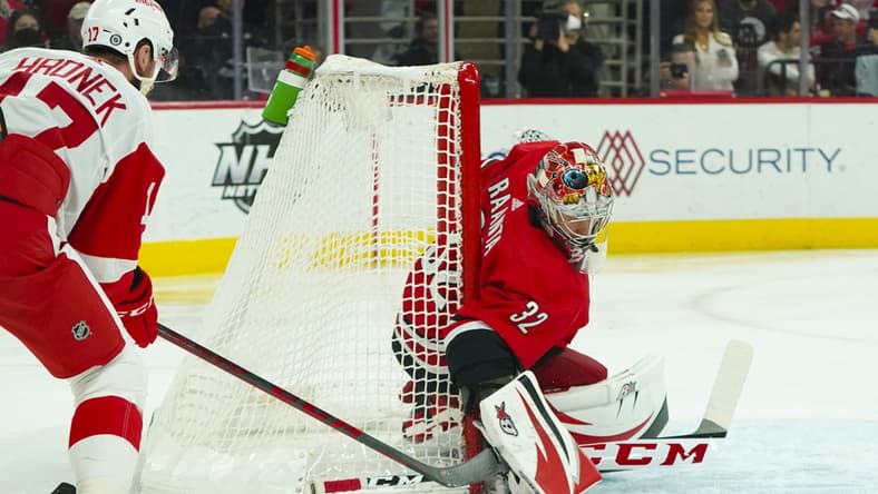 Apr 14, 2022; Raleigh, North Carolina, USA; Carolina Hurricanes goaltender Antti Raanta (32) watches the puck against Detroit Red Wings defenseman Filip Hronek (17) during the first periodat PNC Arena. Mandatory Credit: James Guillory-USA TODAY Sports