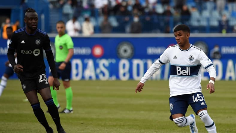 Apr 16, 2022; Montreal, Quebec, CAN; Vancouver Whitecaps midfielder Pedro Vite (45) handles the ball as CF Montr al forward Kei Kamara (23) defends during the second half at Stade Saputo. Mandatory Credit: David Kirouac-USA TODAY Sports