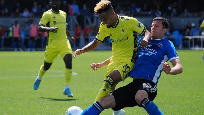 Apr 16, 2022; San Jose, California, USA; San Jose Earthquakes defender Nathan Raphael Pelae Cardoso (13) slide tackles Nashville SC midfielder Hany Mukhtar (10) during the second half at PayPal Park Stadium. Mandatory Credit: Kelley L Cox-USA TODAY Sports