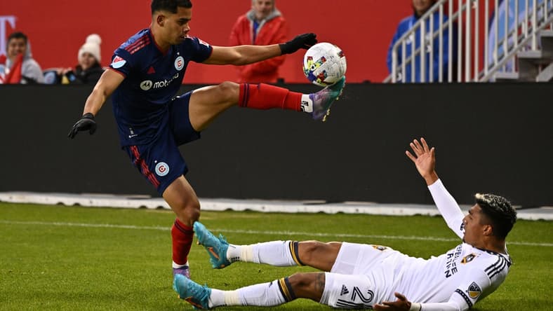 Apr 16, 2022; Chicago, Illinois, USA; Chicago Fire FC defender Miguel ngel Navarro (6) controls the ball over a fallen LA Galaxy defender, Julian Araujo (2), in the first half at Soldier Field. Mandatory Credit: Jamie Sabau-USA TODAY Sports