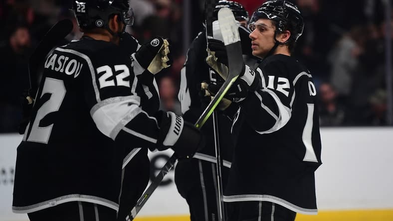 Apr 21, 2022; Los Angeles, California, USA; Los Angeles Kings center Trevor Moore (12) and center Andreas Athanasiou (22) celebrate the victory against the Chicago Blackhawks at Crypto.com Arena. Mandatory Credit: Gary A. Vasquez-USA TODAY Sports