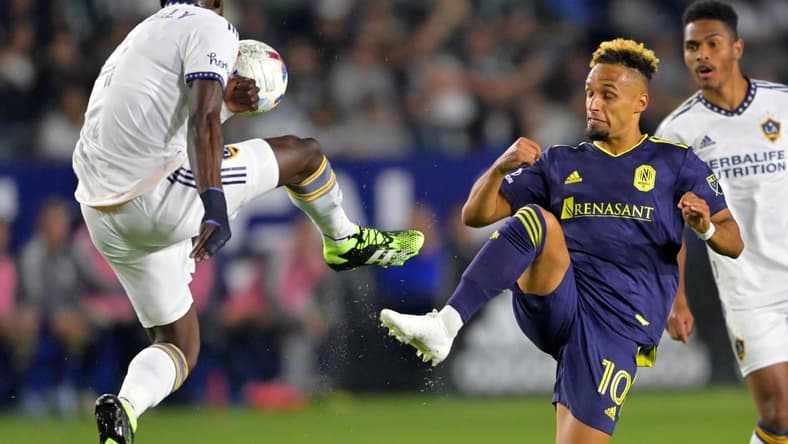Apr 23, 2022; Carson, California, USA;  Los Angeles Galaxy defender Sega Coulibaly (4) and Nashville SC midfielder Hany Mukhtar (10) battle for the ball in the first half at Dignity Health Sports Park. Mandatory Credit: Jayne Kamin-Oncea-USA TODAY Sports